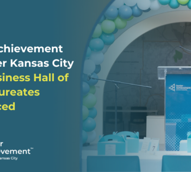 A podium surrounded by a blue and green balloon arch with Junior Achievement of Greater Kansas City's logo