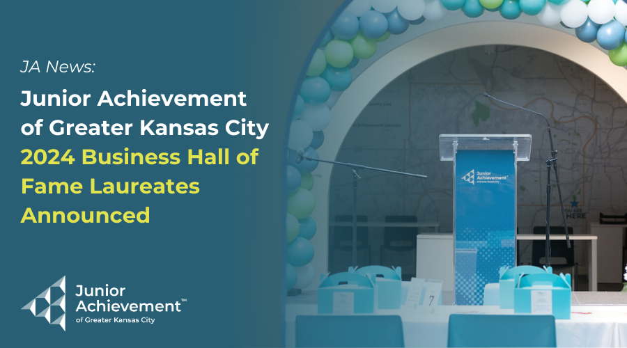 A podium surrounded by a blue and green balloon arch with Junior Achievement of Greater Kansas City's logo