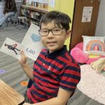 Elementary school student holding up flash cards in classroom