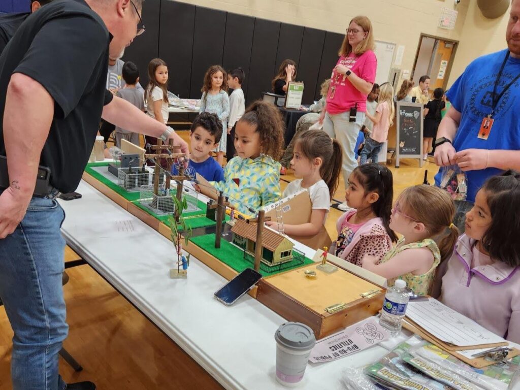 Young students watch a utility demonstration from BPU