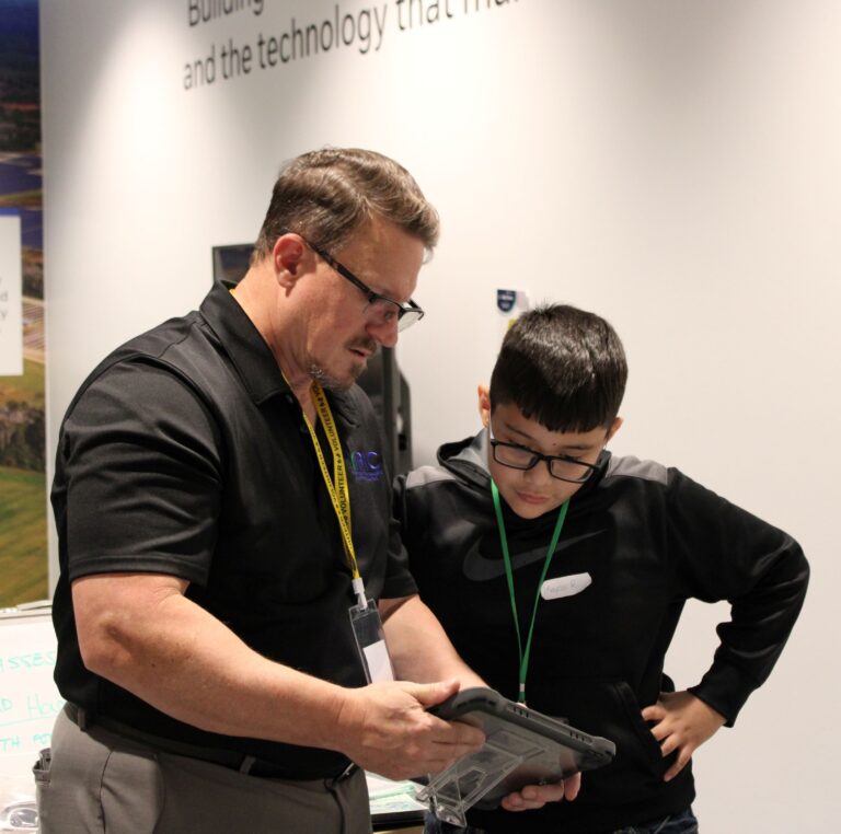 Student and Volunteer in JA BizTown look at an iPad together