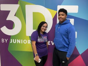 Two high school students standing in front of a mural